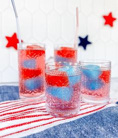 three glasses filled with red, white and blue liquid sitting on top of a table