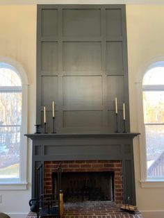 a living room with a fire place and two windows