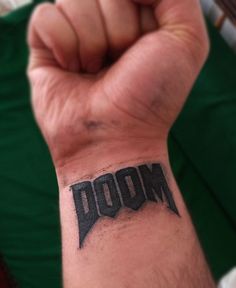 a man's arm with the word boom tattooed on it, in black ink