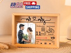 a wooden frame with an image of a bride and groom on it, next to a cat