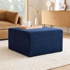 a blue ottoman sitting on top of a white rug