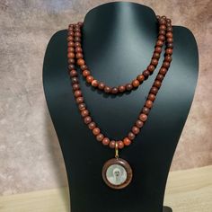 37" This Uniquely Designed Double Sided Photo Pendant Necklace Expertly Combines Wild Country Rosewood and Meditation Beads for an Elegant and Timeless Look. Handcrafted with Quality Materials, The ORIGINAL OSHO Rajneeshpuram Wild Country Rosewood Meditation Beads Mala Necklace Is the Perfect Accessory for Your Mindful Journey. ✥ Pendant size ✥ Necklace length - 37" (w/o pendant 35") ✥ Handmade by Artisans in India ❀❀❀Please look closely at photos as part of item description, the product in the Holistic Wooden Beads Necklace As A Gift, Holistic Style Necklace With Wooden Beads, Holistic Wooden Beads Necklace For Gift, Holistic Style Necklace With Wooden Beads For Gifts, Holistic Style Wooden Beads Necklace For Gifts, Wooden Beads Amulet Necklace As A Gift, Amulet Style Wooden Beaded Necklace For Gifts, Amulet Style Wooden Beaded Necklace As Gift, Wooden Beads Amulet Necklace For Gift