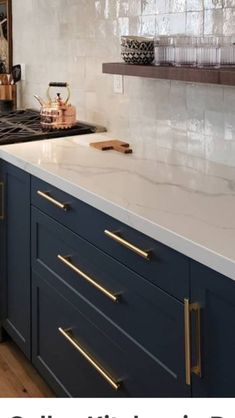 a kitchen with blue cabinets and white counter tops, gold pulls on the handles is featured in this article