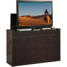 a flat screen tv sitting on top of a wooden trunk