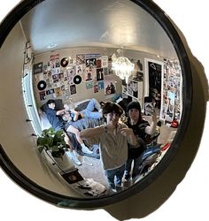 the reflection of two people standing in front of a mirror with pictures on the wall behind them