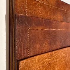 a close up of a brown leather door with stitching on the outside and inside