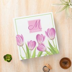 a card with pink tulips on it next to some buttons and other items