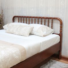 a bed with white sheets and pillows in a room