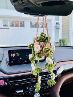 the interior of a car with flowers hanging from it's dash board