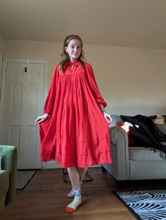 1970s Greek Cotton Gauze Dress. This dress is a pullover with a tie at the neck. The yokes are made of red cotton decorated with red silk ribbon and the body and sleeves of made of tightly gathered, floaty cotton gauze. The ends of the sleeves and the bottom of the skirt also have rows of ribbon. The brand is Piros and there is a small hole at the top of the gauze at the front and a small dark dot on the right front yoke; both are pictured. Bust: 38" Waist: Open Hips: Open Shoulders: 12.5" Sleeves: 29.5" Length: 44.5" Red Cotton Festival Dress, Double Gauze Dress, Red Long Sleeve Peasant Dress, Red Smock Cotton Dress, Casual Long-sleeved Cotton Gauze Dress, Red Long-sleeved Embroidered Cotton Dress, Cotton Gauze Dress, Gauze Dress, Red Silk