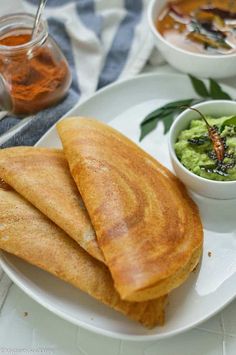 two pieces of bread on a plate with guacamole and salsa