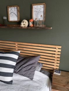 a bed with two wooden shelves on the wall above it and pillows in front of it