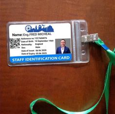 a identification card attached to a lanyard on a wooden table with a green lanyard