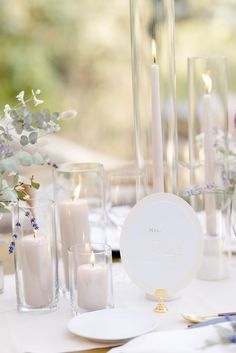 the table is set with candles and plates