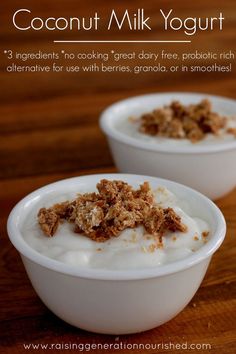 two white bowls filled with yogurt on top of a wooden table