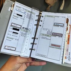 a person holding an open planner in their hand