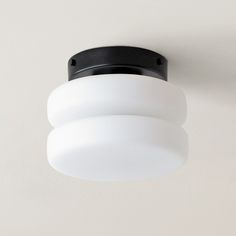 a white ceiling light with black trim on the top and bottom part is dimmer