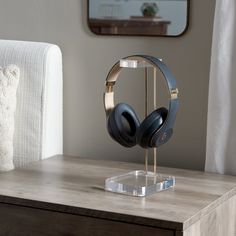 a pair of headphones sitting on top of a wooden table next to a mirror