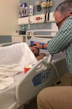 an older man in a hospital bed being assisted by a nurse