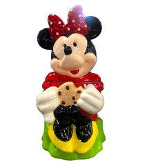 a mickey mouse figurine sitting on top of a piece of food in front of a white background