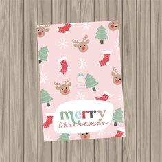 a pink christmas card with reindeers and stockings on it, next to a wooden background