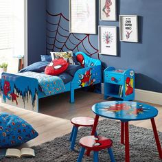 a child's bedroom with blue walls, spiderman bedding and other children's furniture