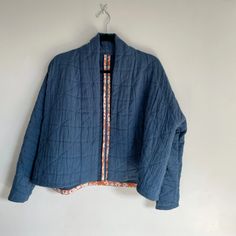 a blue jacket hanging on a white wall