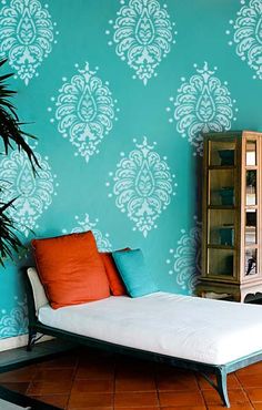 a bed sitting under a window next to a green wall