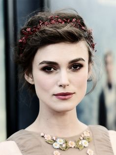 a close up of a person wearing a necklace with flowers on it's head