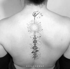 the back of a woman's neck with an image of a sun and planets on it