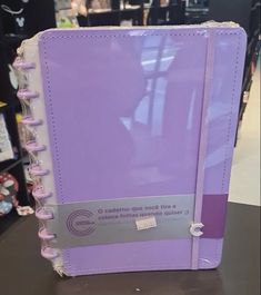 a purple binder sitting on top of a table in front of a store shelf