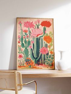 a cactus print hangs on the wall above a desk