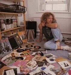 a man sitting on the floor surrounded by records