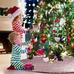 two young children decorating a christmas tree