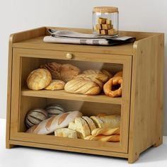 a wooden cabinet with breads and pastries on it's sides, including bagels