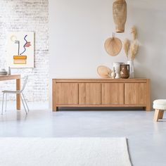 a living room with white walls and wooden furniture in the center, along with an area rug on the floor