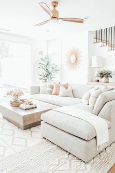 a living room filled with furniture and a ceiling fan