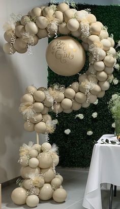 a table topped with balloons and flowers next to a wall