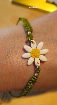 a woman's arm wearing a bracelet with a flower on it