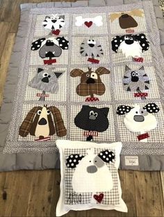 a quilted blanket and pillow on the floor with various animal heads in black and white