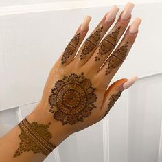 a woman's hand with henna tattoos on it