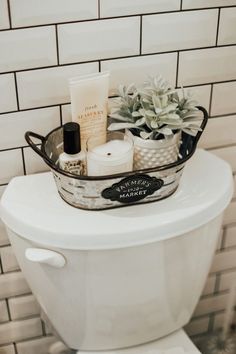 a white toilet sitting in a bathroom next to a tiled wall