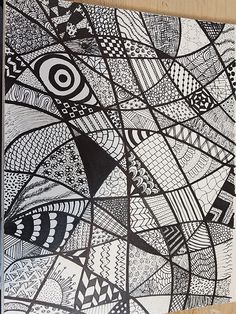 a black and white drawing on paper with an abstract design in the middle, hanging on a wall