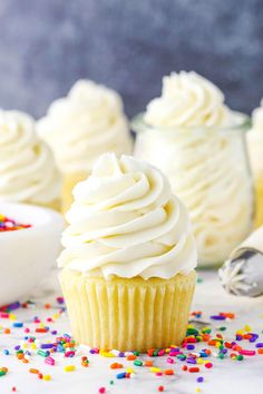 cupcakes with white frosting and sprinkles