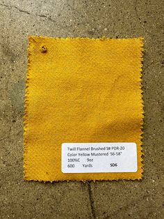 a piece of yellow fabric on the ground with a price tag in front of it