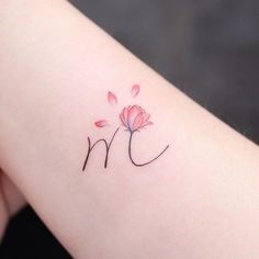 a small pink flower on the left side of the arm, with black writing underneath it