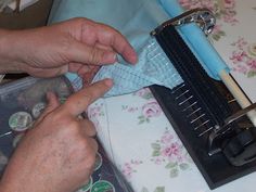 a person is sewing something on a table