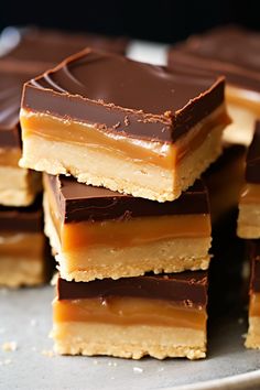 several pieces of chocolate and peanut butter bars stacked on top of each other in rows