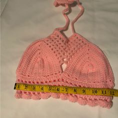 a pink crocheted hat with a measuring tape