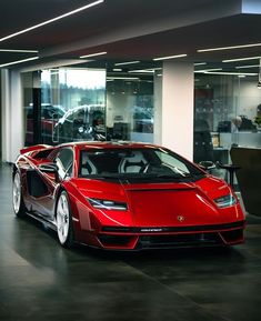 a red sports car is parked in a showroom